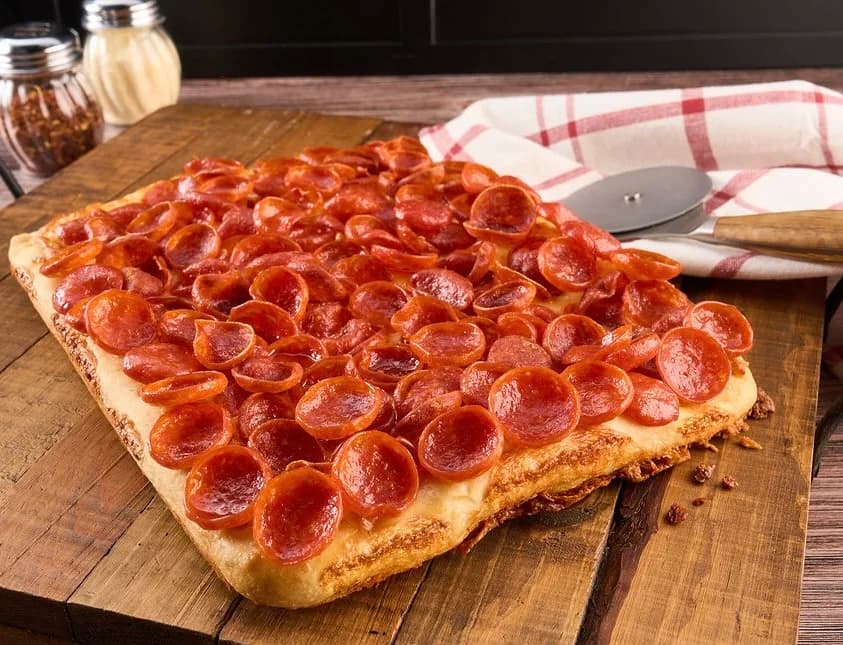 Shared pizza and table details photographed in warm natural light